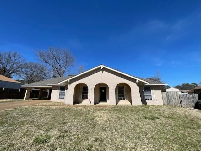 ranch-style home featuring fence and a front yard