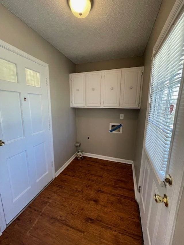 washroom featuring cabinet space, baseboards, dark wood finished floors, a textured ceiling, and washer hookup