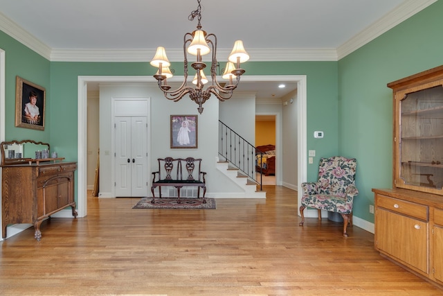 foyer entrance with light wood-style floors, stairs, baseboards, and crown molding
