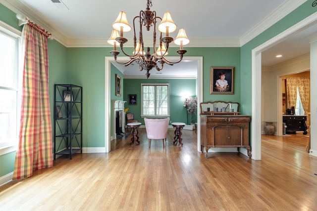 dining area featuring crown molding, a fireplace, a notable chandelier, wood finished floors, and baseboards