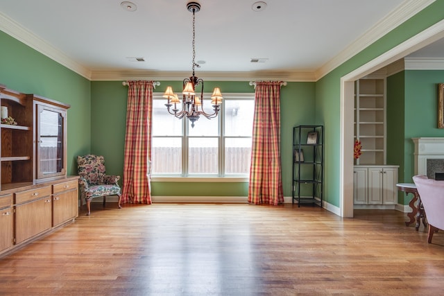 dining room featuring a chandelier, crown molding, and light wood-style floors