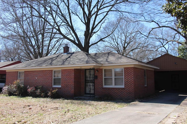 ranch-style home featuring roof with shingles, a chimney, and brick siding