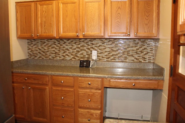 kitchen featuring brown cabinetry and decorative backsplash