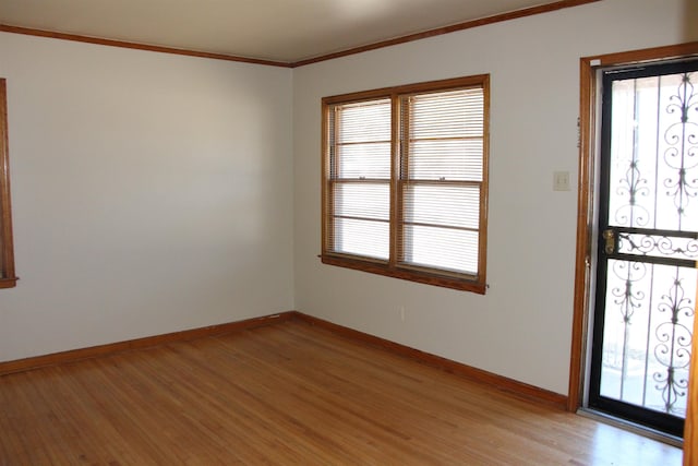 unfurnished room featuring light wood finished floors, baseboards, and ornamental molding