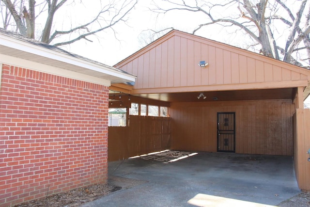 garage with fence and an attached carport