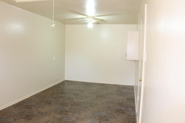 unfurnished room with a ceiling fan and baseboards