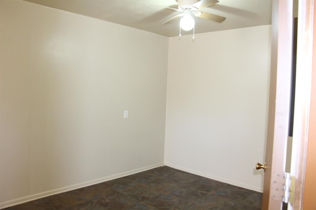 unfurnished room with a ceiling fan and baseboards