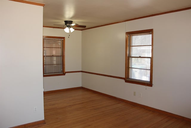 spare room with baseboards, wood finished floors, and ornamental molding