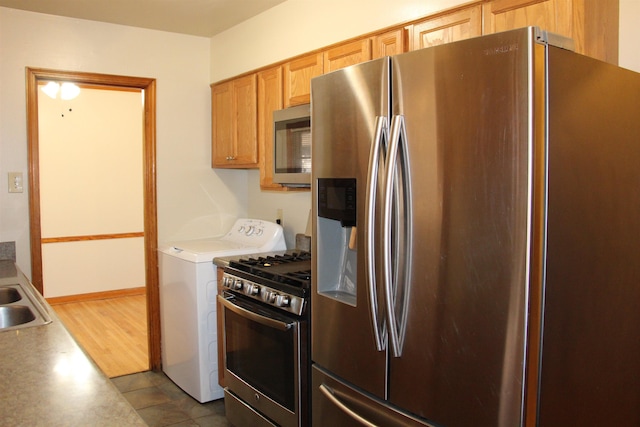 kitchen with baseboards, washer / clothes dryer, stainless steel appliances, light countertops, and a sink