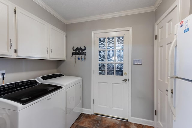 laundry area with baseboards, washing machine and clothes dryer, cabinet space, and crown molding