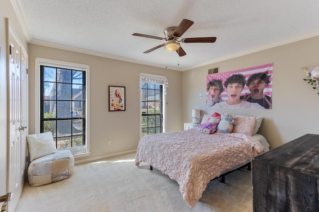 carpeted bedroom featuring a textured ceiling, ornamental molding, visible vents, and a ceiling fan