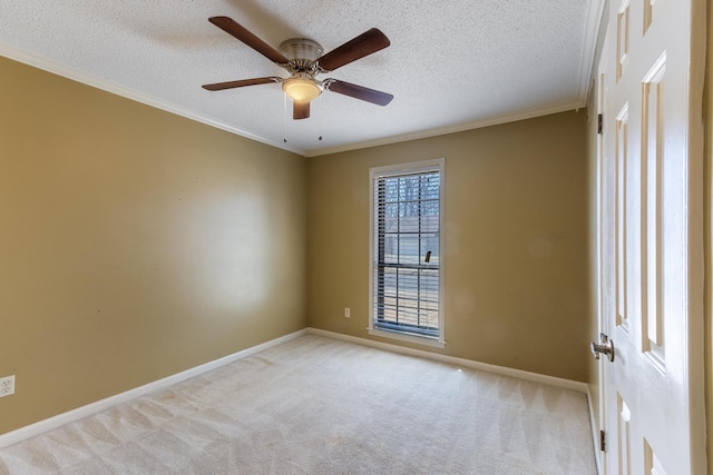 unfurnished room with ceiling fan, a textured ceiling, light colored carpet, baseboards, and crown molding