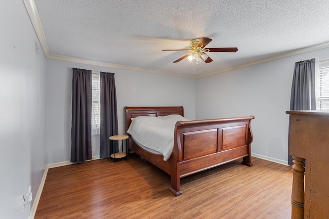 bedroom featuring ornamental molding, a textured ceiling, and light wood finished floors