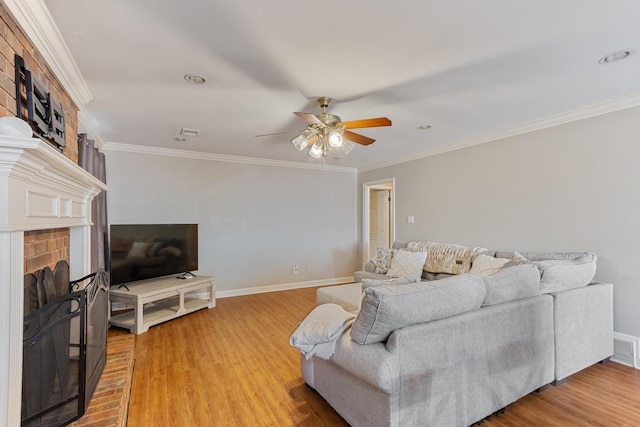 living room featuring ornamental molding, a fireplace, light wood-style floors, and baseboards