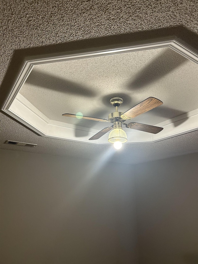 details with a textured ceiling, visible vents, and a ceiling fan