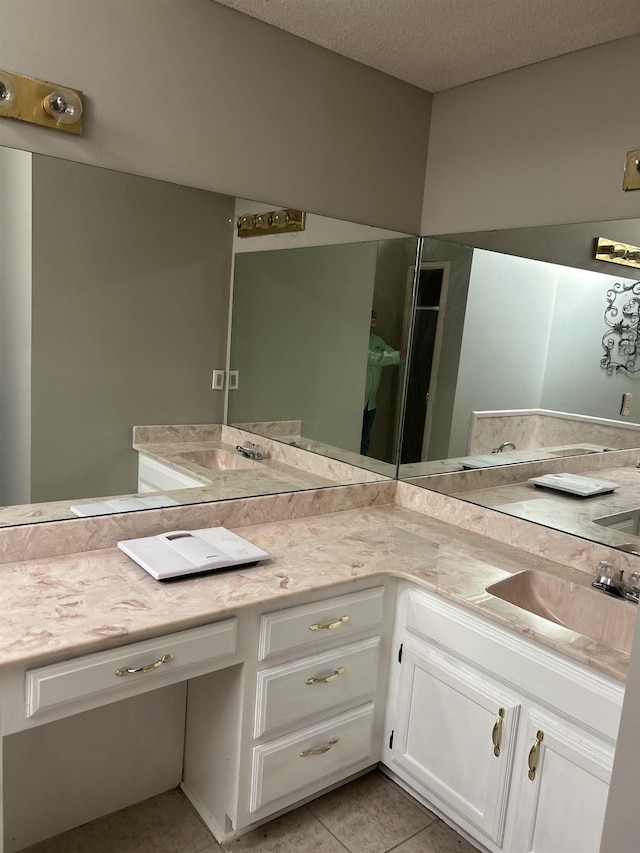 full bath with a textured ceiling, vanity, and tile patterned floors