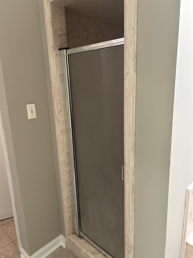 full bathroom featuring baseboards, a shower stall, and tile patterned floors