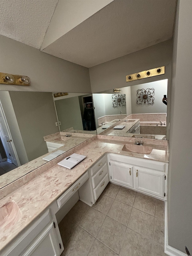 full bath with a textured ceiling, tile patterned flooring, and vanity