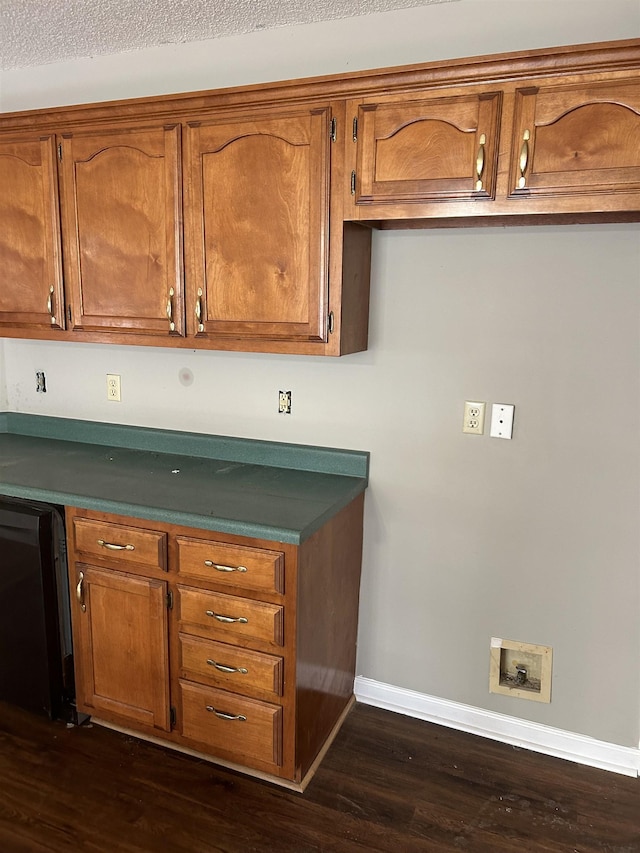 kitchen featuring black dishwasher, dark wood-type flooring, brown cabinetry, and baseboards