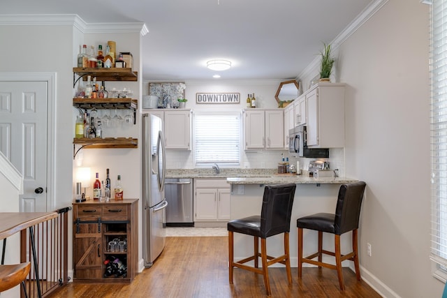 kitchen with white cabinets, appliances with stainless steel finishes, ornamental molding, open shelves, and backsplash