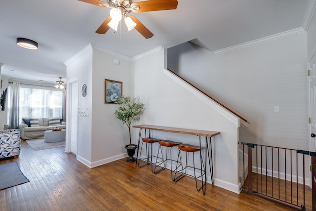 hall with ornamental molding, baseboards, hardwood / wood-style floors, and stairs