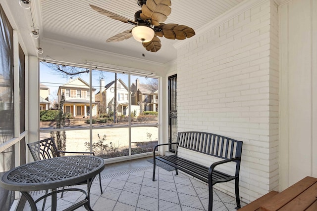 sunroom featuring a residential view and ceiling fan