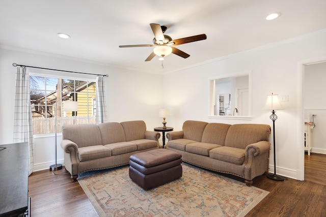 living room with dark wood-style floors, ceiling fan, ornamental molding, and baseboards