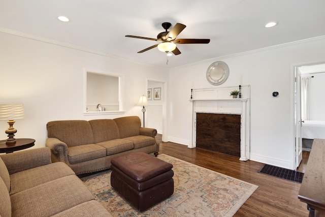 living room featuring dark wood finished floors, recessed lighting, ornamental molding, a ceiling fan, and baseboards