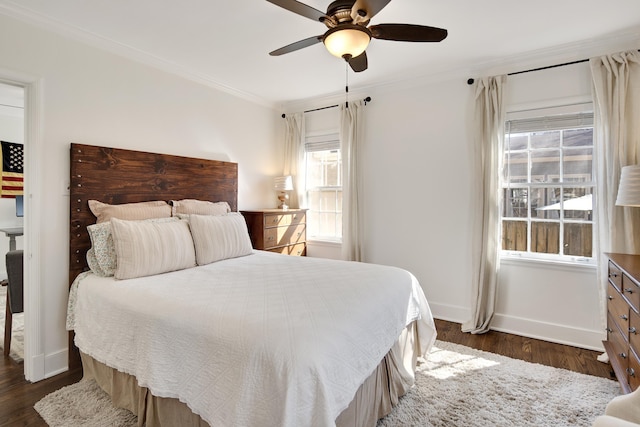 bedroom featuring dark wood-style floors, baseboards, ornamental molding, and a ceiling fan