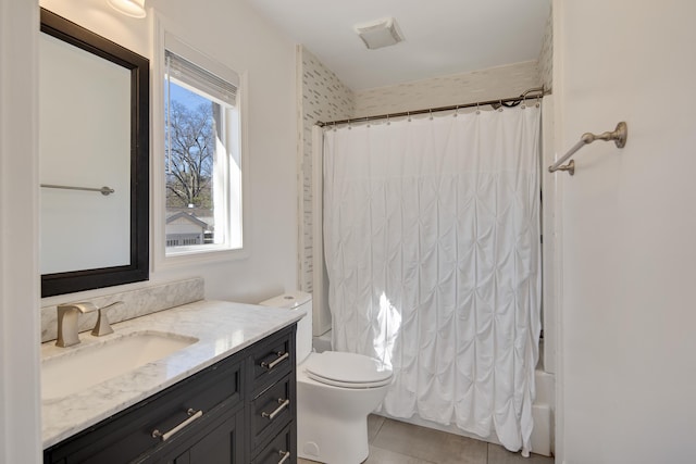 bathroom featuring tile patterned flooring, vanity, toilet, and shower / bath combo with shower curtain