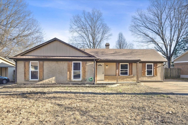 ranch-style house with a chimney and fence