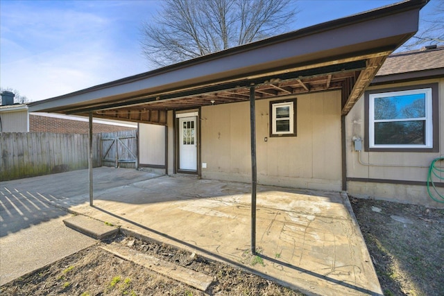 back of house with roof with shingles and fence