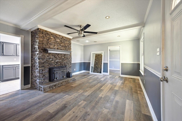 unfurnished living room with a textured ceiling, ceiling fan, wood finished floors, baseboards, and crown molding