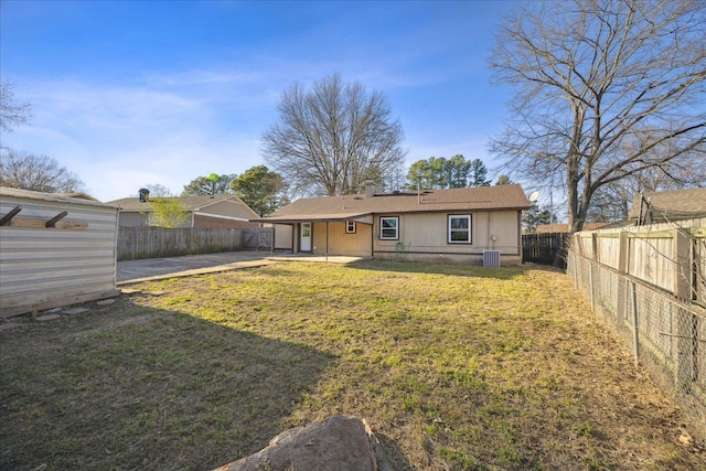 back of house featuring a yard, a fenced backyard, a patio, and central AC unit