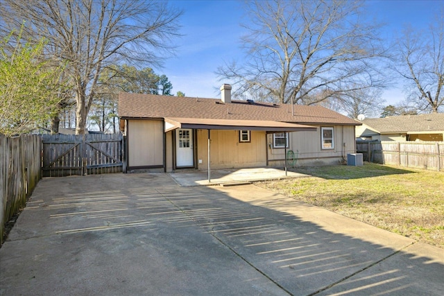 view of front facade with a patio, a front yard, a gate, fence, and cooling unit