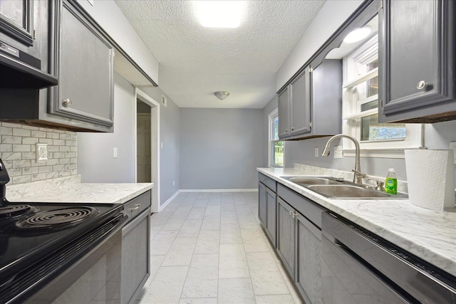 kitchen featuring a sink, baseboards, gray cabinets, backsplash, and black appliances