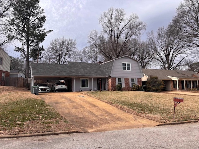 view of front of home with concrete driveway, a gambrel roof, a front lawn, a carport, and brick siding