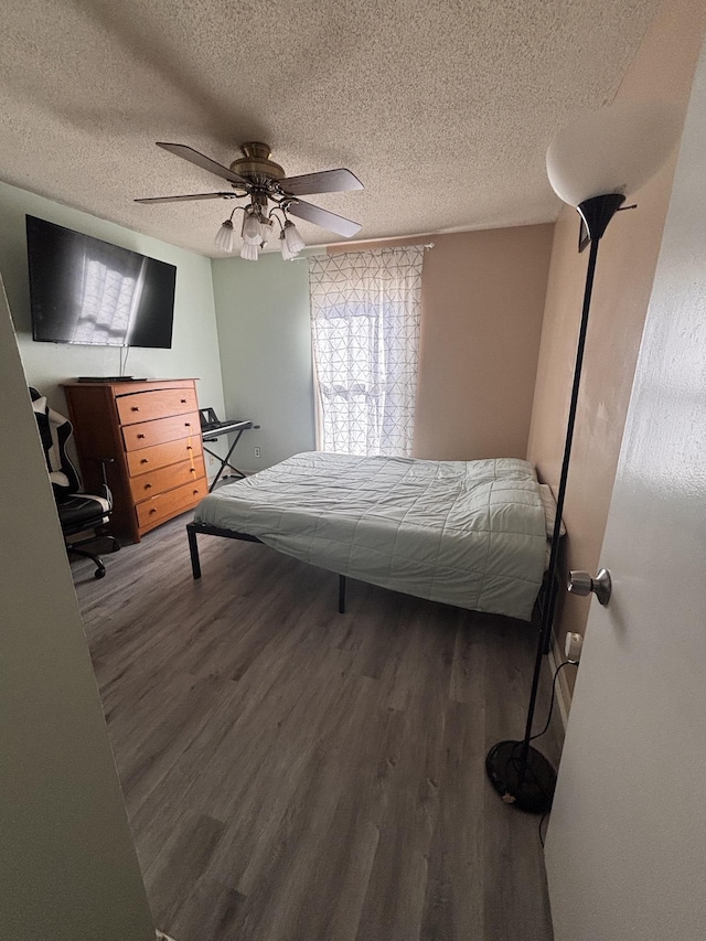 bedroom featuring a textured ceiling, wood finished floors, and a ceiling fan