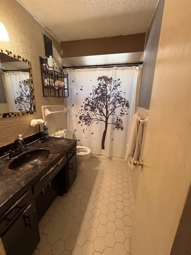 full bath with a shower with shower curtain, toilet, tile patterned flooring, a textured ceiling, and vanity