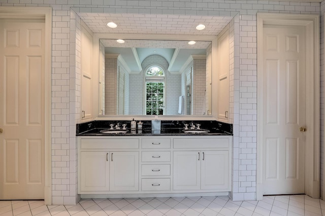 full bath featuring double vanity, tile patterned flooring, and a sink