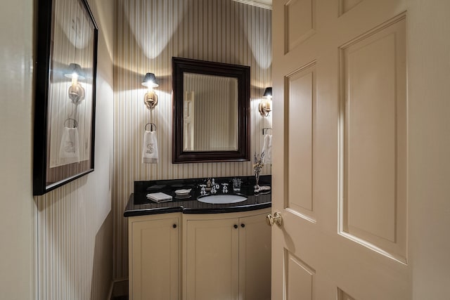 bathroom with wallpapered walls and vanity