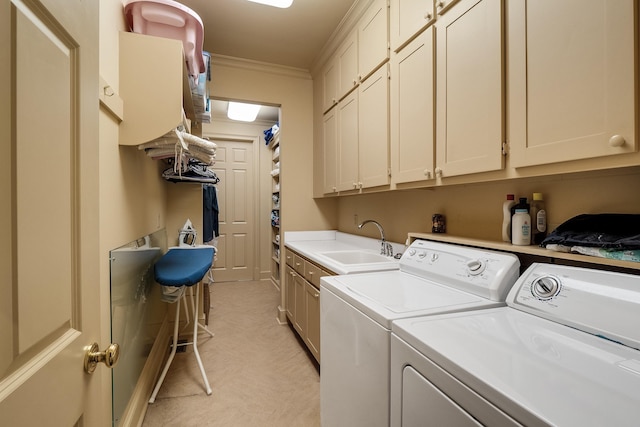 clothes washing area featuring crown molding, independent washer and dryer, cabinet space, and a sink