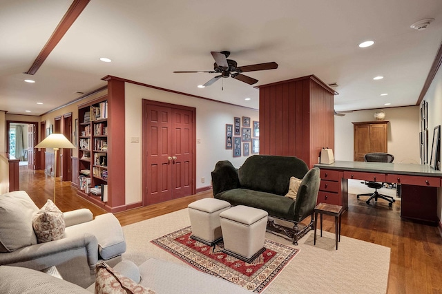 living room featuring crown molding, baseboards, wood finished floors, and recessed lighting