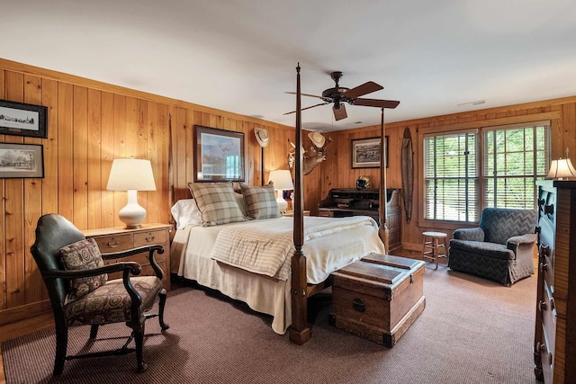 carpeted bedroom with visible vents and wooden walls