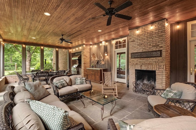 living room with a wealth of natural light, wooden ceiling, and a brick fireplace