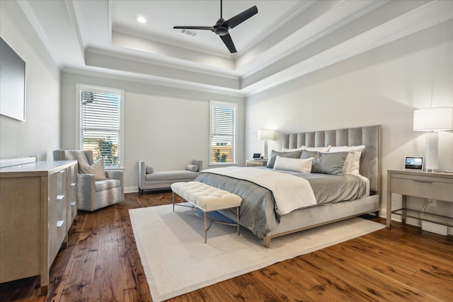 bedroom featuring crown molding, multiple windows, a raised ceiling, and dark wood finished floors