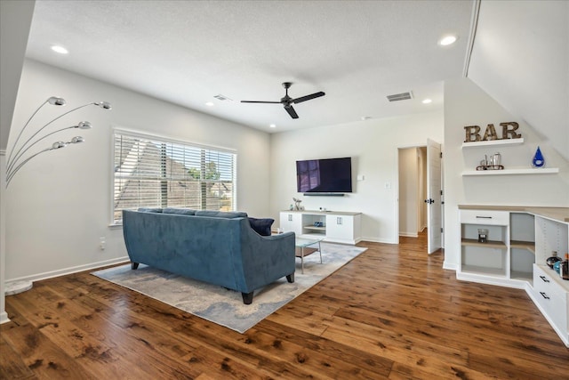 living room featuring hardwood / wood-style flooring, baseboards, visible vents, and a ceiling fan