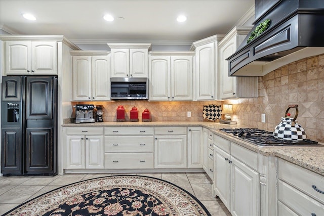 kitchen with premium range hood, appliances with stainless steel finishes, tasteful backsplash, and light stone counters