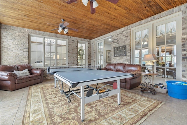 recreation room with tile patterned flooring, wood ceiling, and brick wall