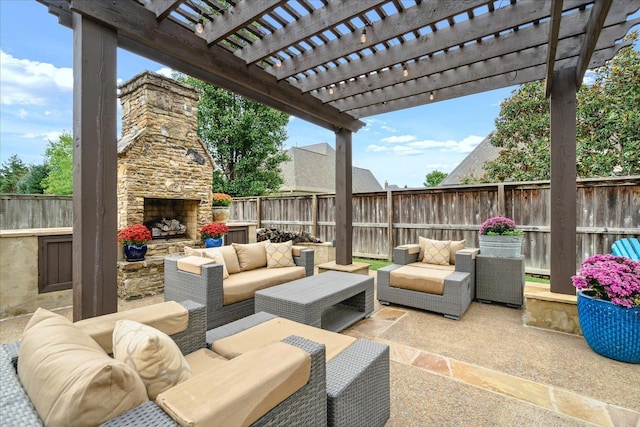 view of patio / terrace with an outdoor living space with a fireplace and a fenced backyard